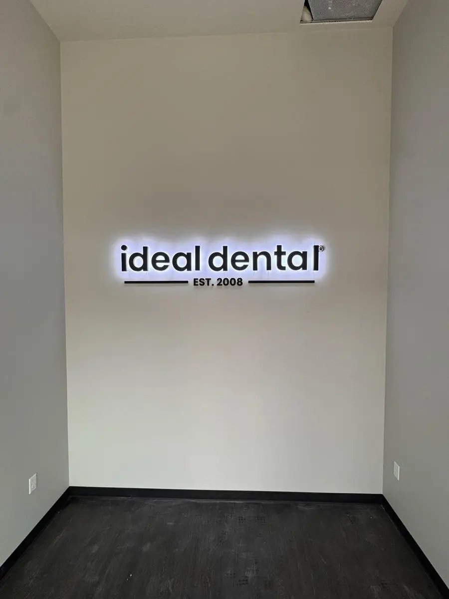 Backlit Ideal Dental lobby logo sign with halo glow installed on interior wall in Dallas