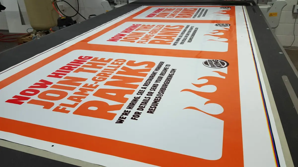 Burger King banners on digital cutting table for precision finishing in Dallas