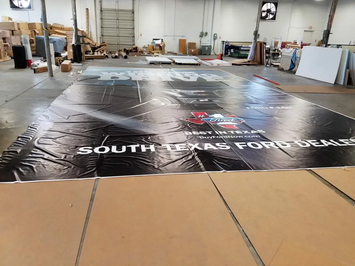 Billboard-size South Texas Ford Dealers vinyl banner laid out during grand format printing in Dallas