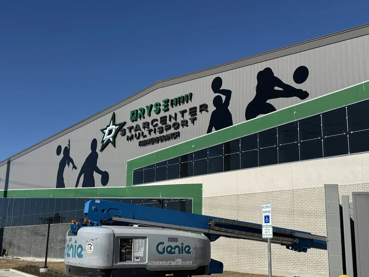Channel letter sign installation with boom lift at StarCenter Multisport building Dallas