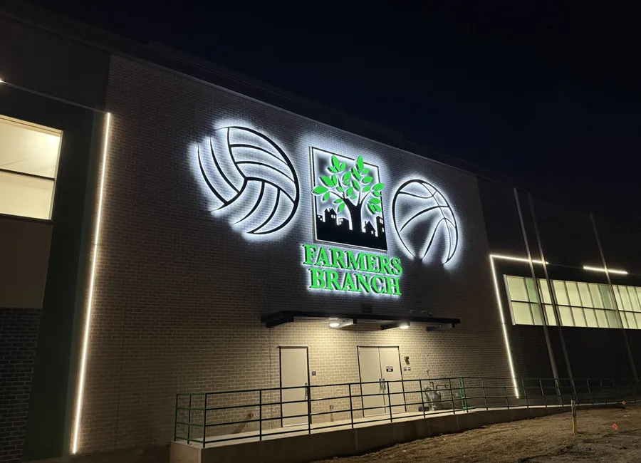 Illuminated building sign with sports logos in Farmers Branch Dallas at night