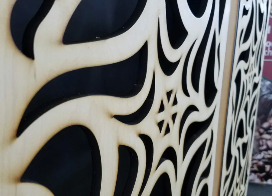 Close-up detail of an intricate laser-cut plywood decorative panel in Dallas