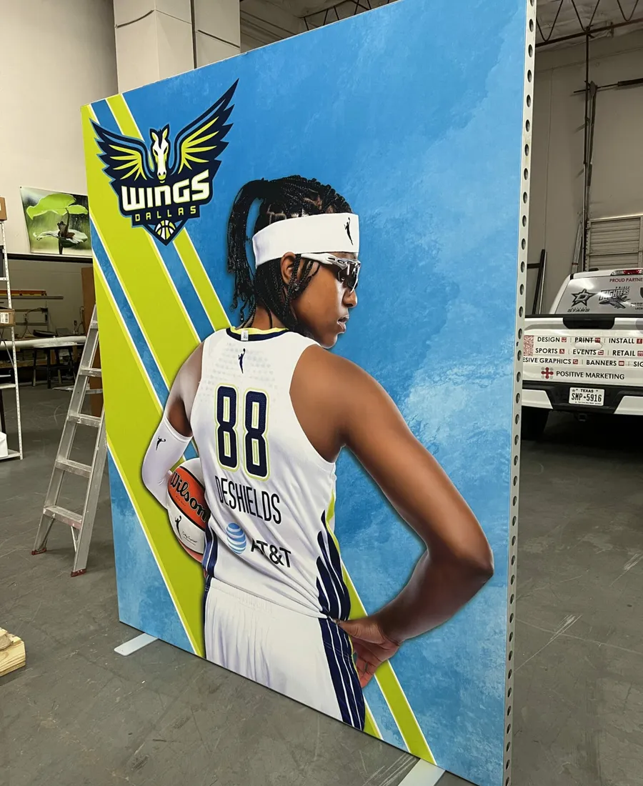 Tall tension fabric display of Dallas Wings player DeShields printed in-house in Dallas